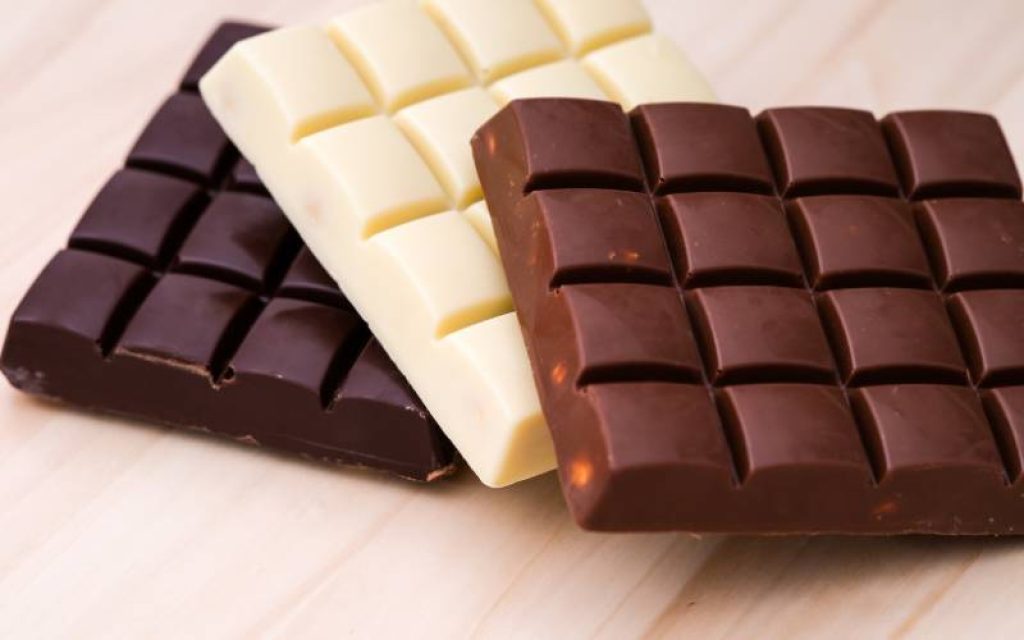 Três barras de chocolate representando os tipos de cada um deles: amargo, branco e ao leite. 